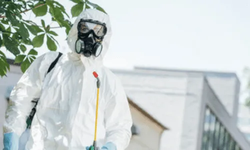 disinfestatore in tuta bianca con maschera in un'abitazione
